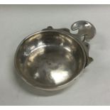 An Antique silver wine taster with scroll handle.