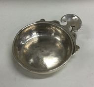 An Antique silver wine taster with scroll handle.