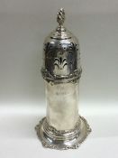A tall silver lighthouse shaped caster decorated w