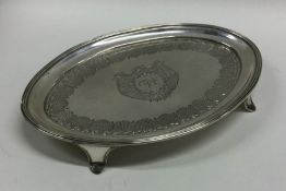 An oval Georgian silver teapot stand on four sprea