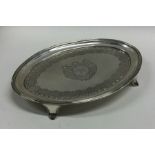 An oval Georgian silver teapot stand on four sprea