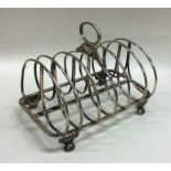 A heavy Georgian silver toast rack on reeded taper