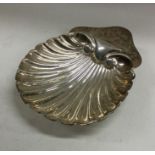 A heavy Edwardian silver butter shell on ball feet