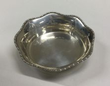 A small silver bottle stand with shaped decoration