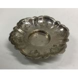 A Continental silver saucer decorated with flowers