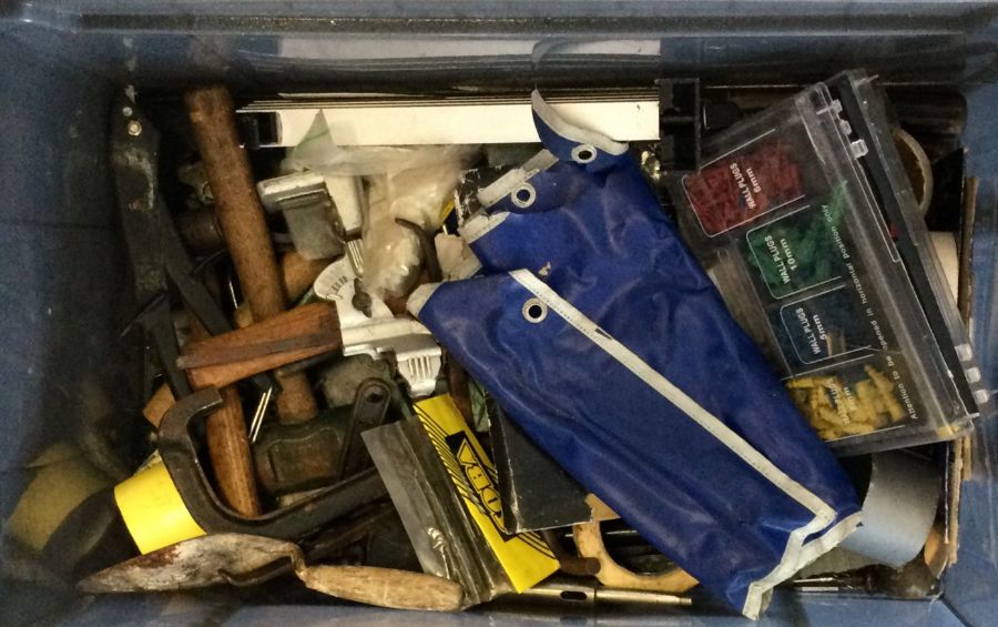 A box containing assorted tools comprising various hammers and a drill