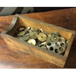 A wooden box containing assorted clockwork gears. Est. £5 - £10.