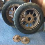 A pair of spoked wheels and caps to suit a Morris Commercial. Est. £10 - £20.