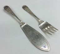 A pair of fancy silver fish servers with aesthetic