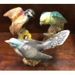 Three Beswick figures of birds in bright colours.