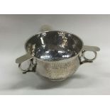 A small silver three handled tig with textured bod