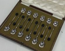 A boxed set of twelve silver bean top spoons. Shef