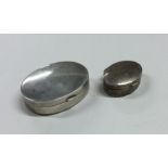 A plain oval silver pill box together with one oth