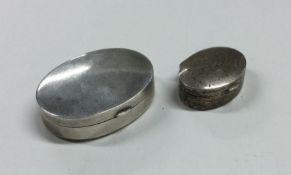 A plain oval silver pill box together with one oth