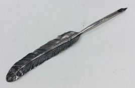 A silver quill in the form of a feather. Apparentl