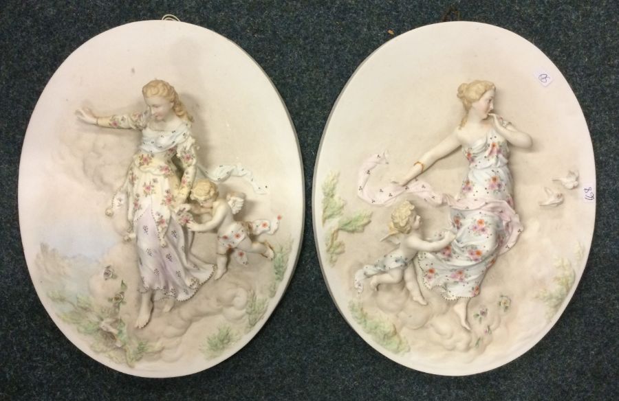 A pair of Continental wall plaques depicting child