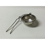 A silver pierced tea infuser on fine link chain. A