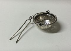 A silver pierced tea infuser on fine link chain. A