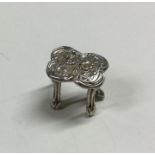 A small miniature silver table with embossed decor