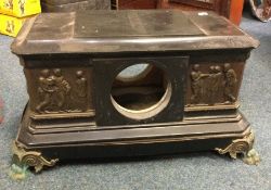 A large slate clock mount decorated with brass fig