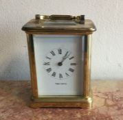 A brass cased carriage clock with white enamelled