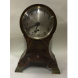 A large mahogany inlaid mantle clock on shaped bas