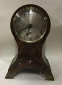 A large mahogany inlaid mantle clock on shaped bas
