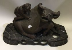 A carved wooden figure of an ox on wooden base. Es