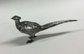 A silver figure of a pheasant with textured body.