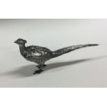 A silver figure of a pheasant with textured body.