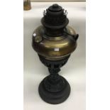 An old cast iron and brass lamp. Est. £20 - £30.