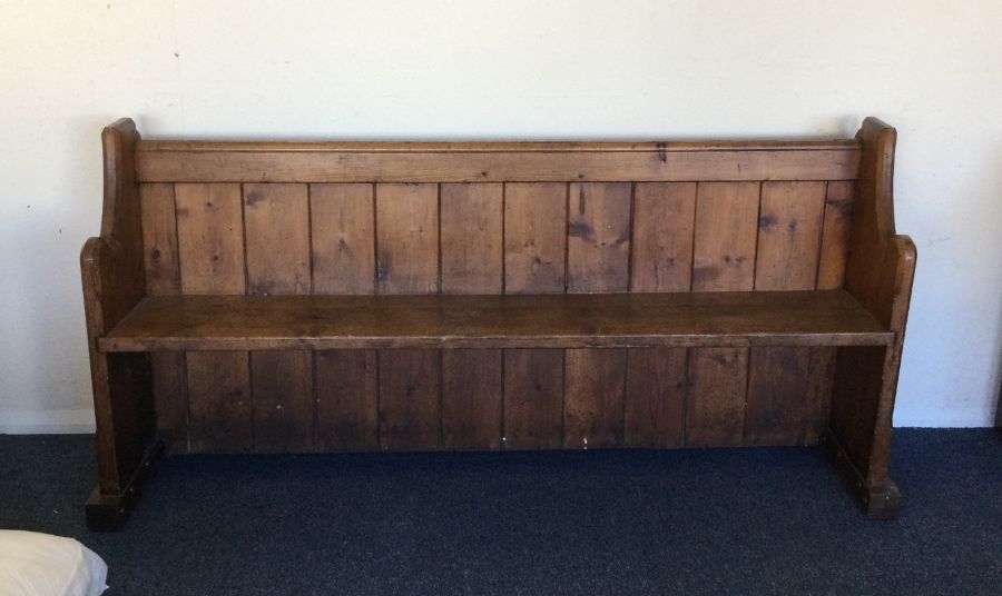 An old pitch pine settle. Est. £50 - £80.