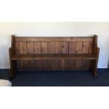 An old pitch pine settle. Est. £50 - £80.