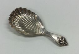 A heavy fancy silver caddy spoon with fluted bowl.