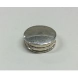 A plain circular silver pill box with hinged top.