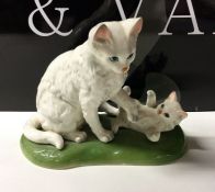An attractive porcelain figure of a cat with kitte