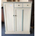 A painted pine two drawer cupboard on pedestal bas