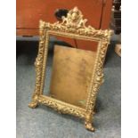 A large brass picture frame with pierced decoratio
