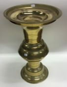 A tall Chinese brass spill vase on spreading foot.