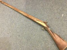 An old flintlock rifle. Est. £40 - £60.