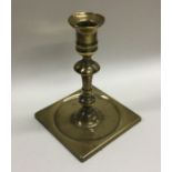 A heavy Antique square based brass candlestick wit