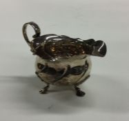 An Edwardian silver cream jug of half fluted desig