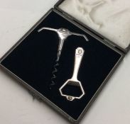 A stylish boxed silver corkscrew together with mat