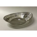 A large oval pierced silver dish decorated with sw