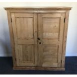 A pitch pine two door cupboard. Est. £50 - £80.