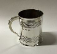 A Victorian tapering silver mug of reeded design.