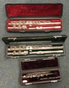 Two cased flutes together with a cased piccolo. Es