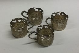A group of four chased silver spirit cups decorate