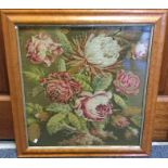 A maple framed and glazed tapestry depicting flowe