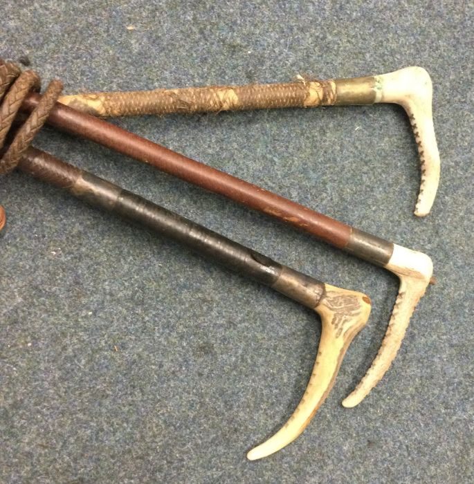 A group of three old hunting whips. Est. £20 - £30